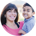 Mother smiles as she holds up her son.